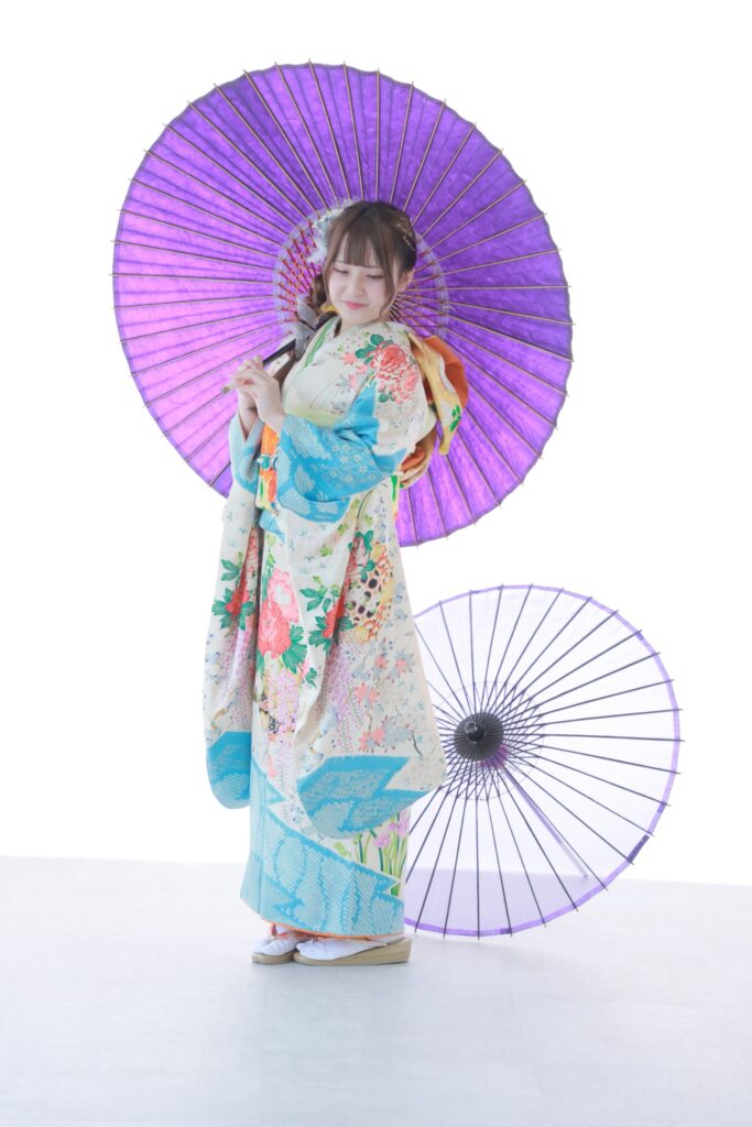 水色の花柄振袖を着て紫の和傘と撮影した振袖の全身写真