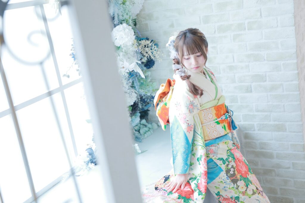 花柄の振袖を着た女性を明るい窓辺のスタジオで撮影した写真