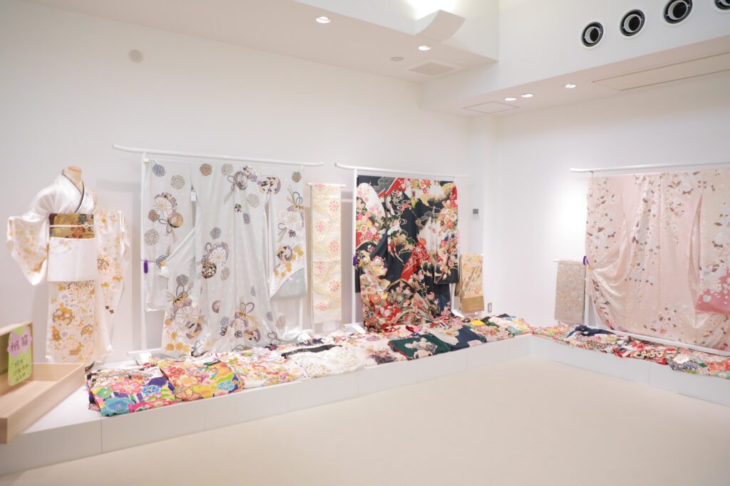 白や黒、ピンクなどさまざまな色柄の振袖を展示している振袖専門店