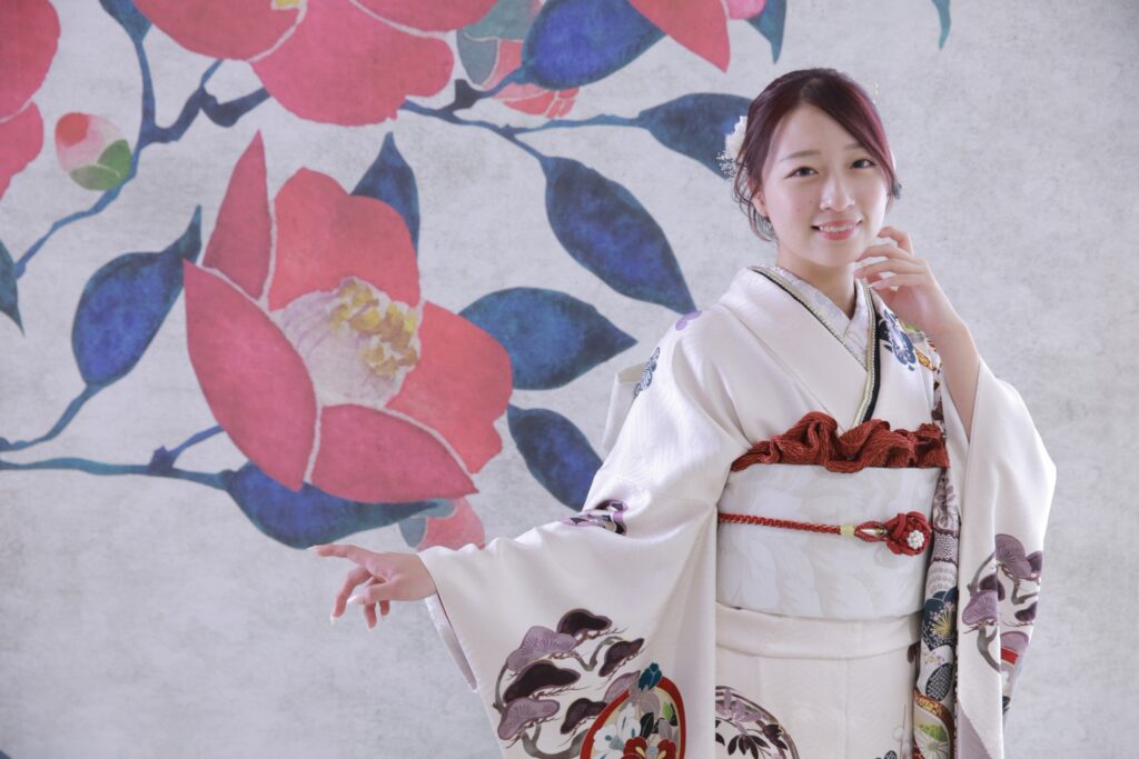 白地の振袖を着た女性を大きな花の背景で撮影した振袖ポートレート
